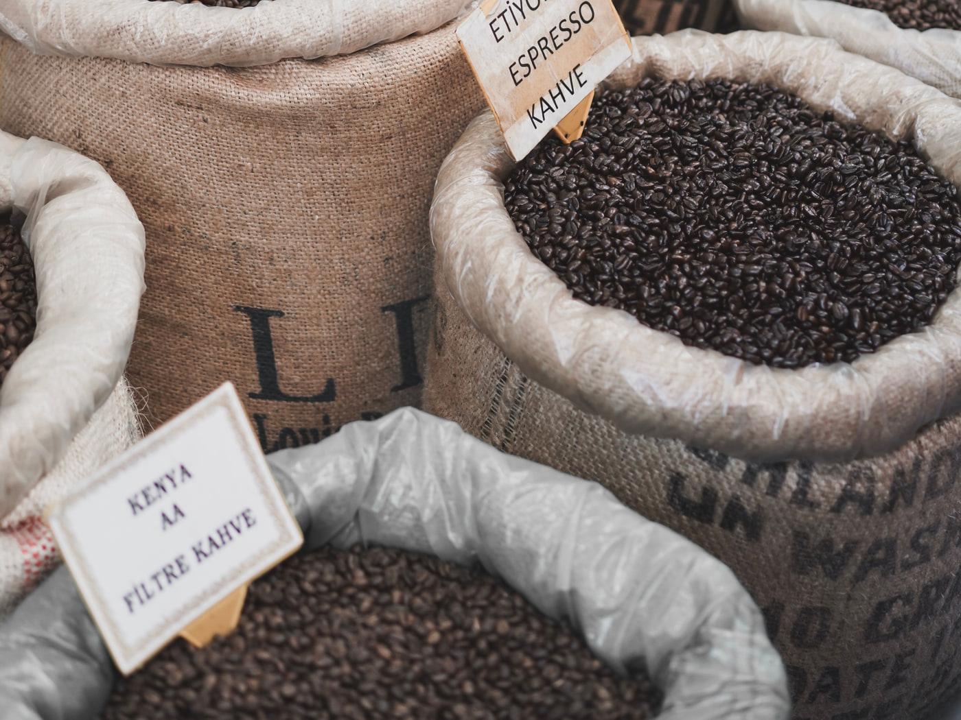 Sacks of green coffee on the floor, labelled by origin